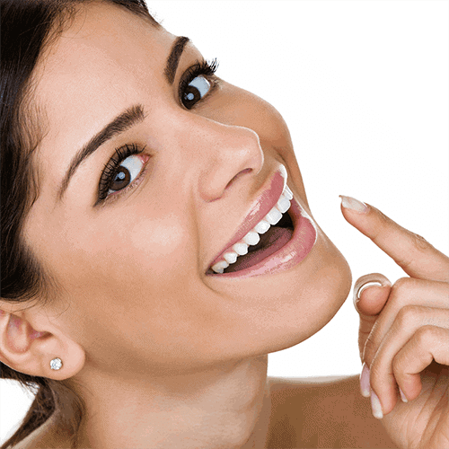 Woman smiling pointing to her perfect teeth